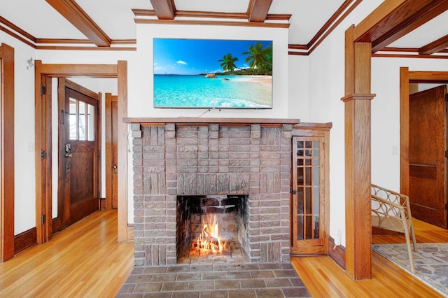 unfurnished living room with hardwood / wood-style floors, a brick fireplace, and beam ceiling