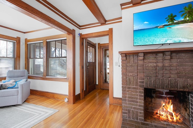 unfurnished living room with a fireplace, ornamental molding, and light wood-type flooring