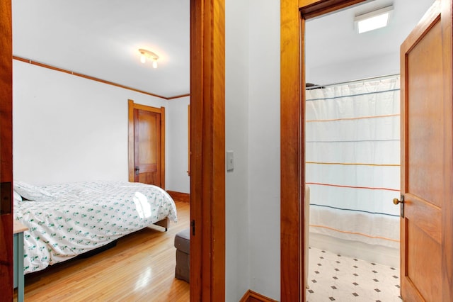 bedroom featuring crown molding and light hardwood / wood-style flooring