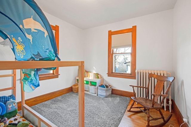 bedroom with hardwood / wood-style floors and radiator