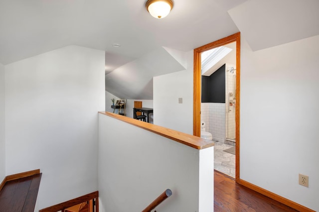 hallway featuring lofted ceiling and wood-type flooring