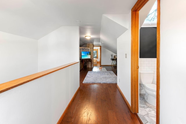 corridor featuring dark hardwood / wood-style flooring and vaulted ceiling