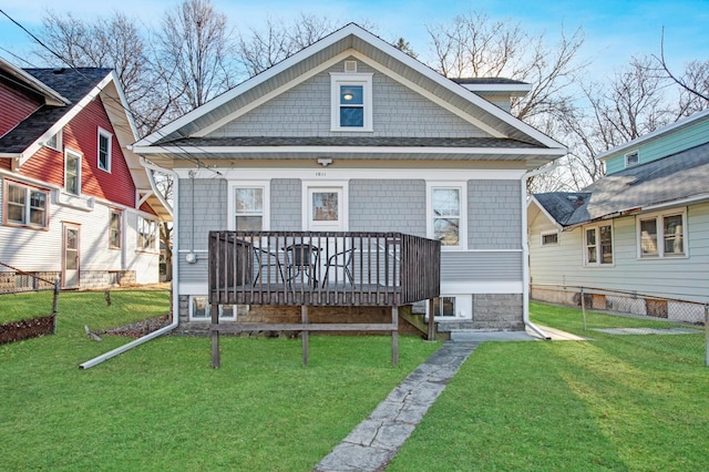 back of house featuring a lawn and a deck