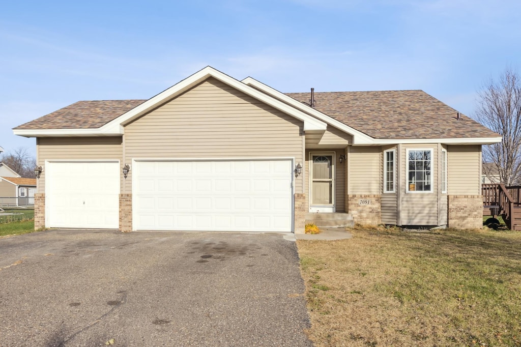 view of front of house with a garage and a front lawn