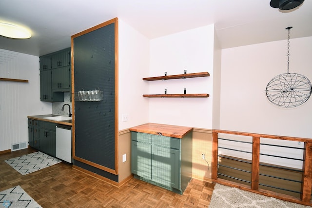 kitchen with dishwasher, dark parquet floors, hanging light fixtures, and sink