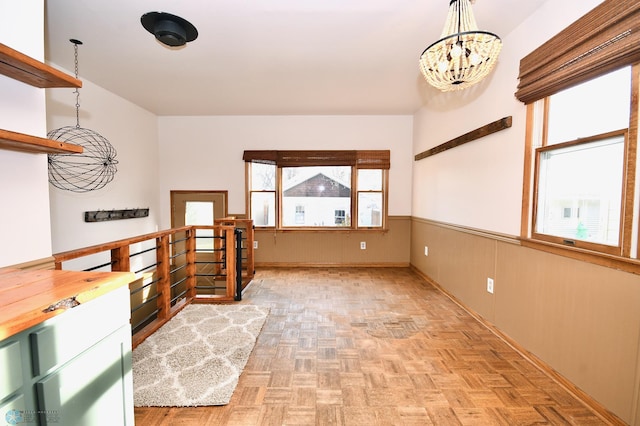 interior space featuring light parquet floors, a healthy amount of sunlight, and a chandelier