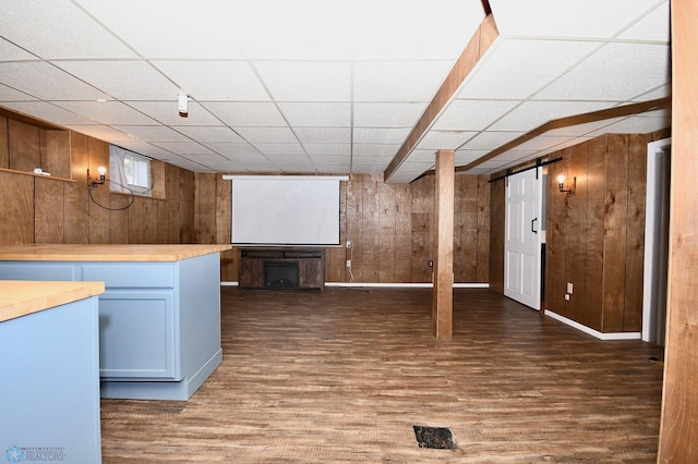 basement with dark hardwood / wood-style flooring and wooden walls