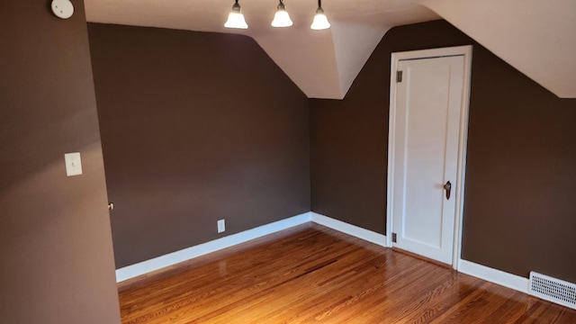 bonus room with wood-type flooring and lofted ceiling