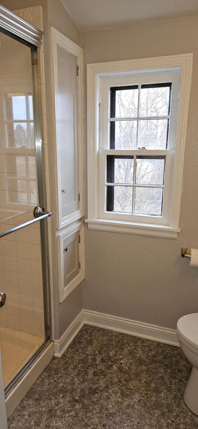 bathroom with toilet and an enclosed shower