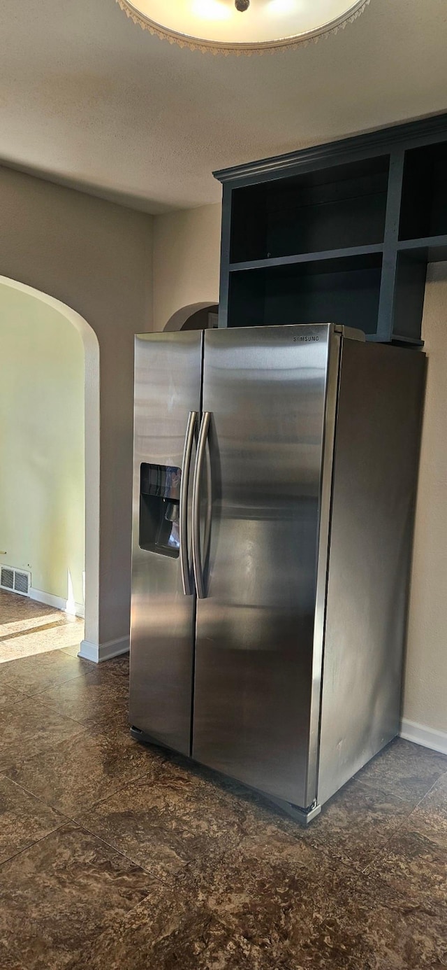 kitchen featuring stainless steel fridge with ice dispenser and a textured ceiling