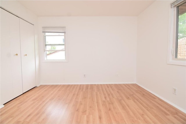 unfurnished bedroom with a closet and light hardwood / wood-style floors