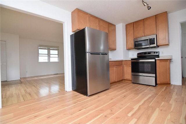 kitchen featuring track lighting, stainless steel appliances, and light hardwood / wood-style flooring