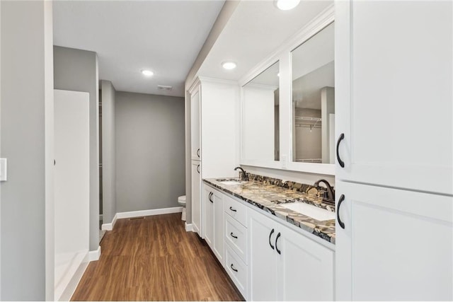 bathroom with hardwood / wood-style flooring, vanity, and toilet