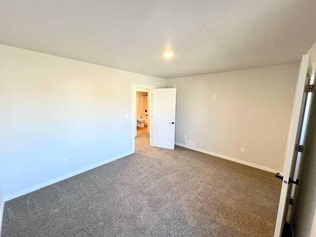 empty room with carpet and baseboards