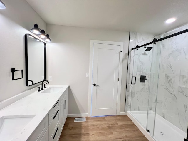 full bath featuring baseboards, wood finished floors, a sink, and visible vents