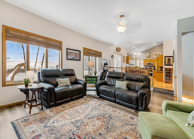 living room featuring ceiling fan, lofted ceiling, beverage cooler, and light hardwood / wood-style flooring