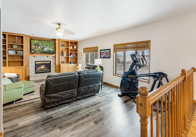 living room featuring hardwood / wood-style flooring, a brick fireplace, and ceiling fan