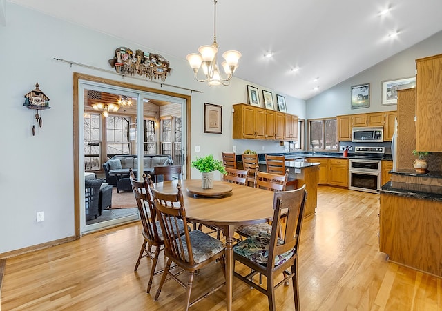 dining space featuring a notable chandelier, high vaulted ceiling, and light wood-type flooring