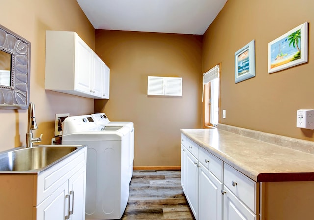 washroom with cabinets, washer and clothes dryer, sink, and light hardwood / wood-style flooring