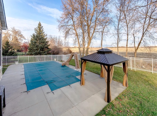 view of swimming pool featuring a gazebo, a water slide, a patio area, and a lawn