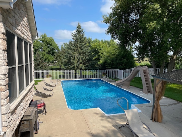 view of pool with a patio and a water slide