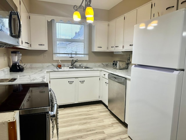 kitchen with stainless steel appliances, sink, decorative light fixtures, a notable chandelier, and white cabinets