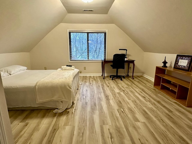 bedroom with light wood-type flooring and lofted ceiling