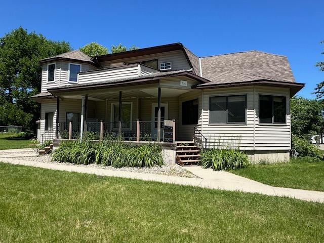 view of front of property featuring covered porch and a front yard