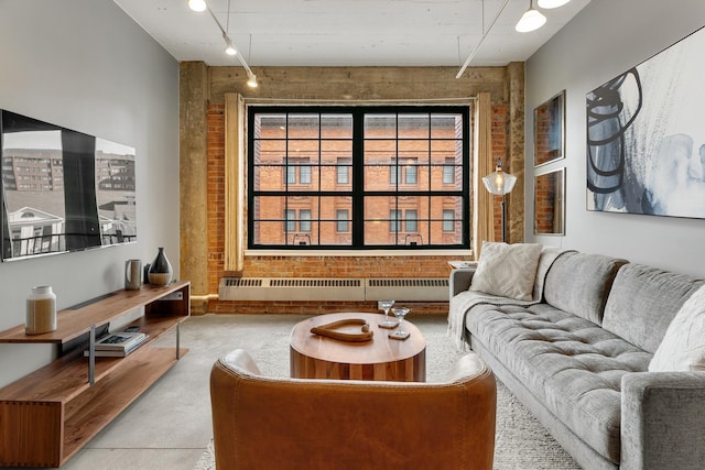 living room with concrete flooring, radiator, and brick wall