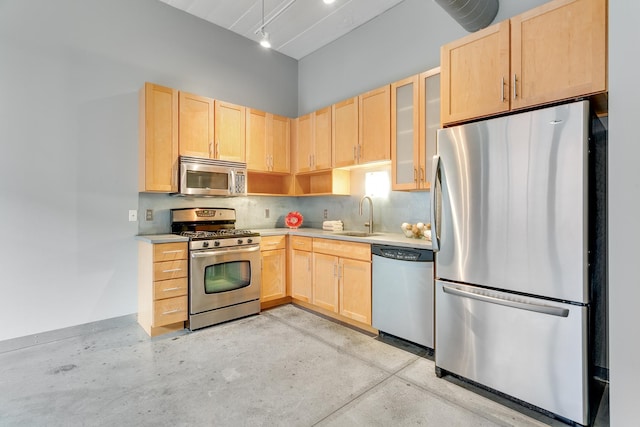 kitchen with light brown cabinets, sink, appliances with stainless steel finishes, and tasteful backsplash