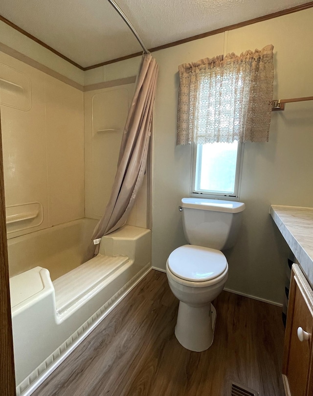 bathroom featuring crown molding, toilet, a textured ceiling, and hardwood / wood-style flooring