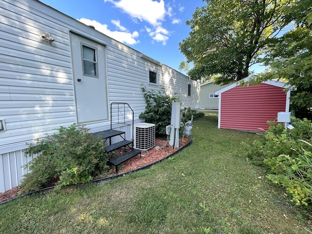 view of yard with central air condition unit and a shed