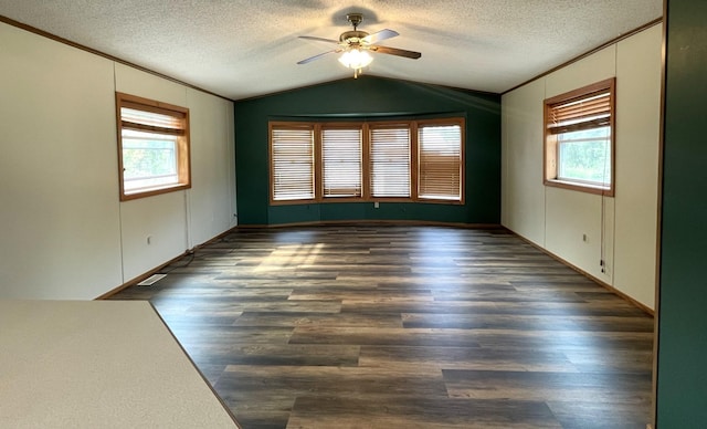 unfurnished room featuring a textured ceiling, vaulted ceiling, ceiling fan, and dark wood-type flooring