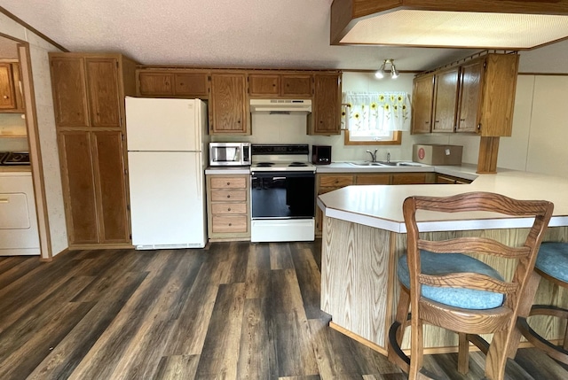 kitchen featuring white appliances, sink, a textured ceiling, dark hardwood / wood-style flooring, and washer / dryer