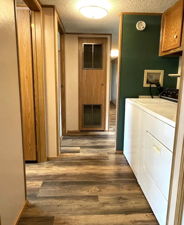 washroom featuring cabinets, a textured ceiling, separate washer and dryer, and dark hardwood / wood-style floors