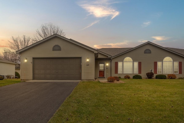 ranch-style home with a yard and a garage