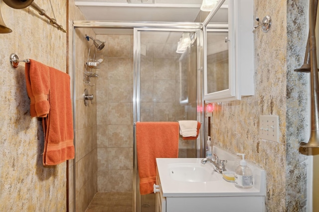 bathroom featuring vanity and a shower with door