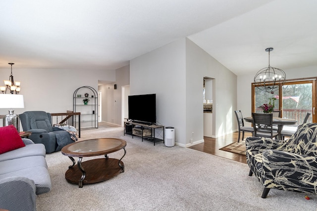 carpeted living area with a chandelier, vaulted ceiling, and baseboards