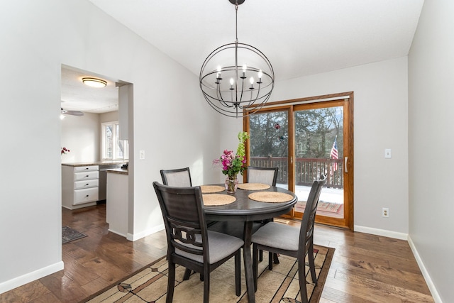 dining area featuring dark wood-style floors, a healthy amount of sunlight, baseboards, and an inviting chandelier