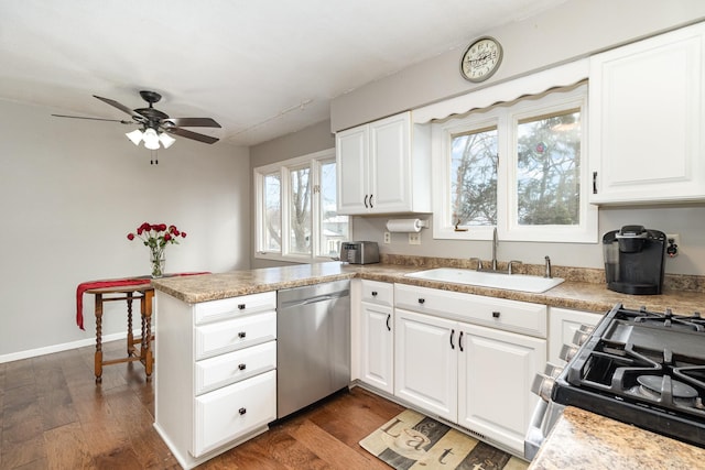 kitchen with a peninsula, dark wood finished floors, stainless steel appliances, and a sink