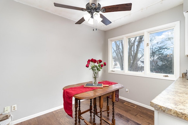 dining space featuring a ceiling fan, baseboards, visible vents, and wood finished floors