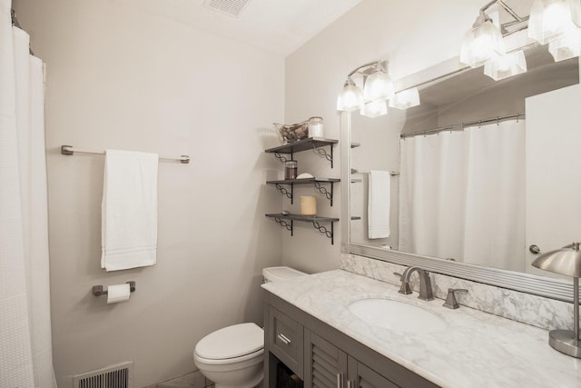 bathroom with visible vents, vanity, and toilet