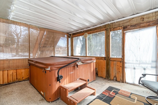 unfurnished sunroom with plenty of natural light and a hot tub