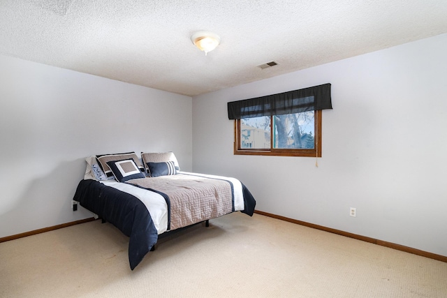 bedroom with carpet floors, visible vents, a textured ceiling, and baseboards