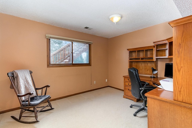 office area featuring baseboards, visible vents, a textured ceiling, and light colored carpet