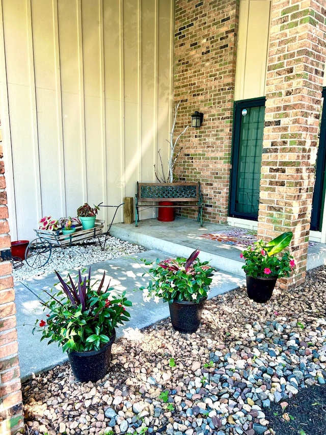 view of exterior entry with brick siding and board and batten siding