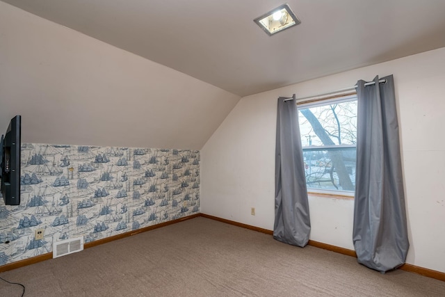 additional living space featuring carpet flooring and lofted ceiling