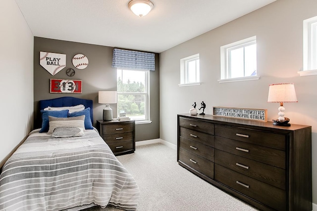 bedroom with light colored carpet and multiple windows