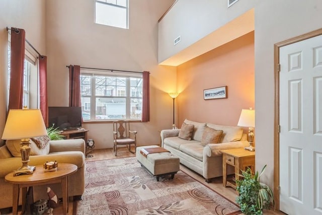 living room with a healthy amount of sunlight and a towering ceiling