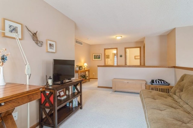 carpeted living room featuring a textured ceiling